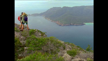 Hikers at top of mountain looking down over Wine Glass Bay