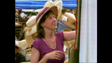 Woman choosing hat at a stall at a flea market