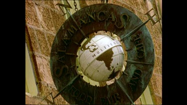 Detail of a shop sign "Multicultural". Globe spinning around.