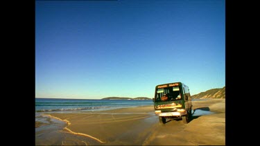 Four Wheel Drive Bus driving along beach. Fraser Island