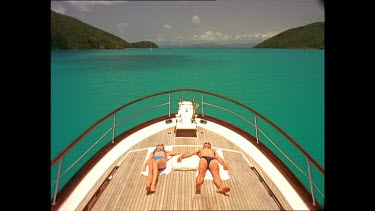 Couple tanning on deck of boat. Whitsunday's.