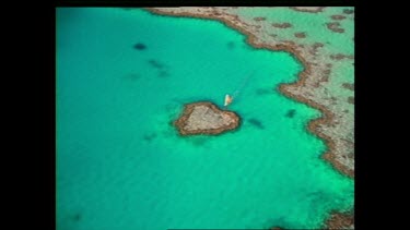 Windsurfer passes over centre of heart shaped reef. Whitsunday's.