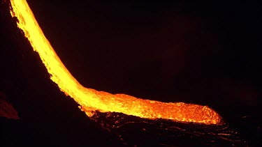 Active volcano. Lava flow. River of lava pouring down slope. Night.