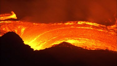 Active volcano. Magma coming to the surface. At the surface magma is called lava. The lava flows slowly along a channel. Night