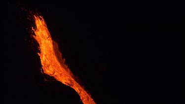 Volcano. Lava flowing down channel. Night