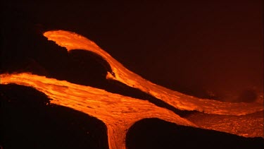 Volcano. Lava flowing down channel. Night. Lava flowing quickly.