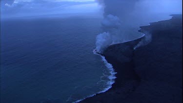 Where the edge of the Kilauea lava delta meets the ocean a line of steam rises into the air