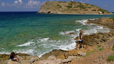 Tourists Watch Waves Crash Onto Rocks, Gulf Of Mirabello, Crete, Greece