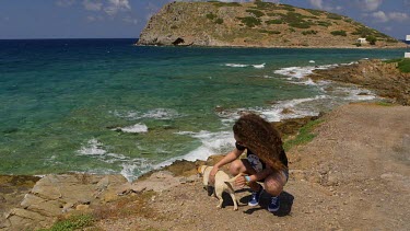 Teenage Girl Strokes Local Dog, Mochlos, Crete, Greece