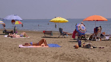 Sunbathing On Beach With Parasols, Lido, Venice, Italy