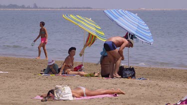 Sunbathing On Beach With Parasols, Lido, Venice, Italy