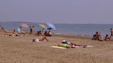 Sunbathing On Beach With Parasols, Lido, Venice, Italy