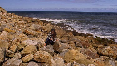 Young Girl Throws Stones Into Sea, North Sea, Scarborough, North Yorkshire, England, United Kingdom
