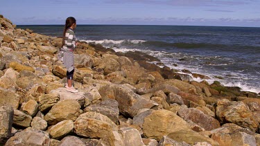 Young Girl Throws Stones Into Sea, North Sea, Scarborough, North Yorkshire, England, United Kingdom