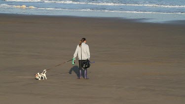 Women Walks Dogs On Beach, North Bay, Scarborough, North Yorkshire, England