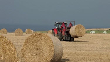 Red Tractor Collecting Straw Bales, A174, North Yorkshire, England