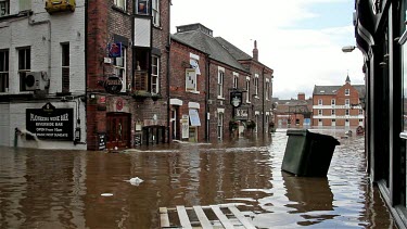 Wheelie Bin And Other Debris Float Down The Street, City Of York, England