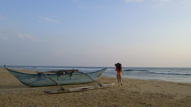 Woman Runs To Ocean Past Fishing Boat, Bentota Beach, Sri Lanka