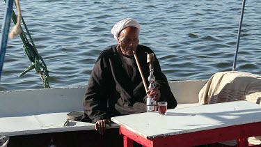 Old Egyptian Man Smokes Pipe, River Nile, Luxor, Egypt