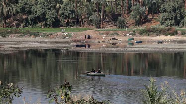 Men In Rowing Boat Near Bank, River Nile, Luxor, Egypt
